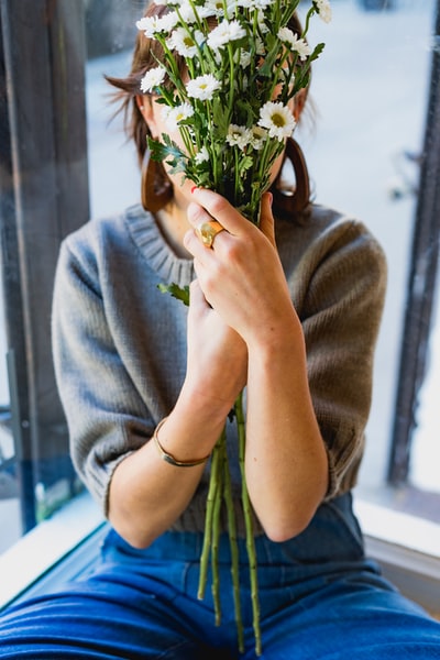 用白花遮住脸的女人